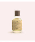 Bottle of perfume with a label on a light pink background