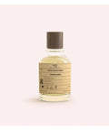 Bottle of perfume with a label on a light pink background